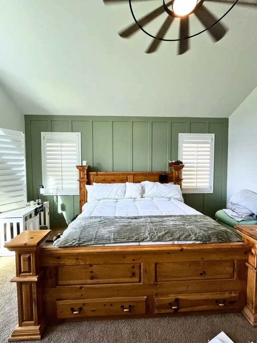 Custom board and batten accent wall with sage green painted finish in a master bedroom
