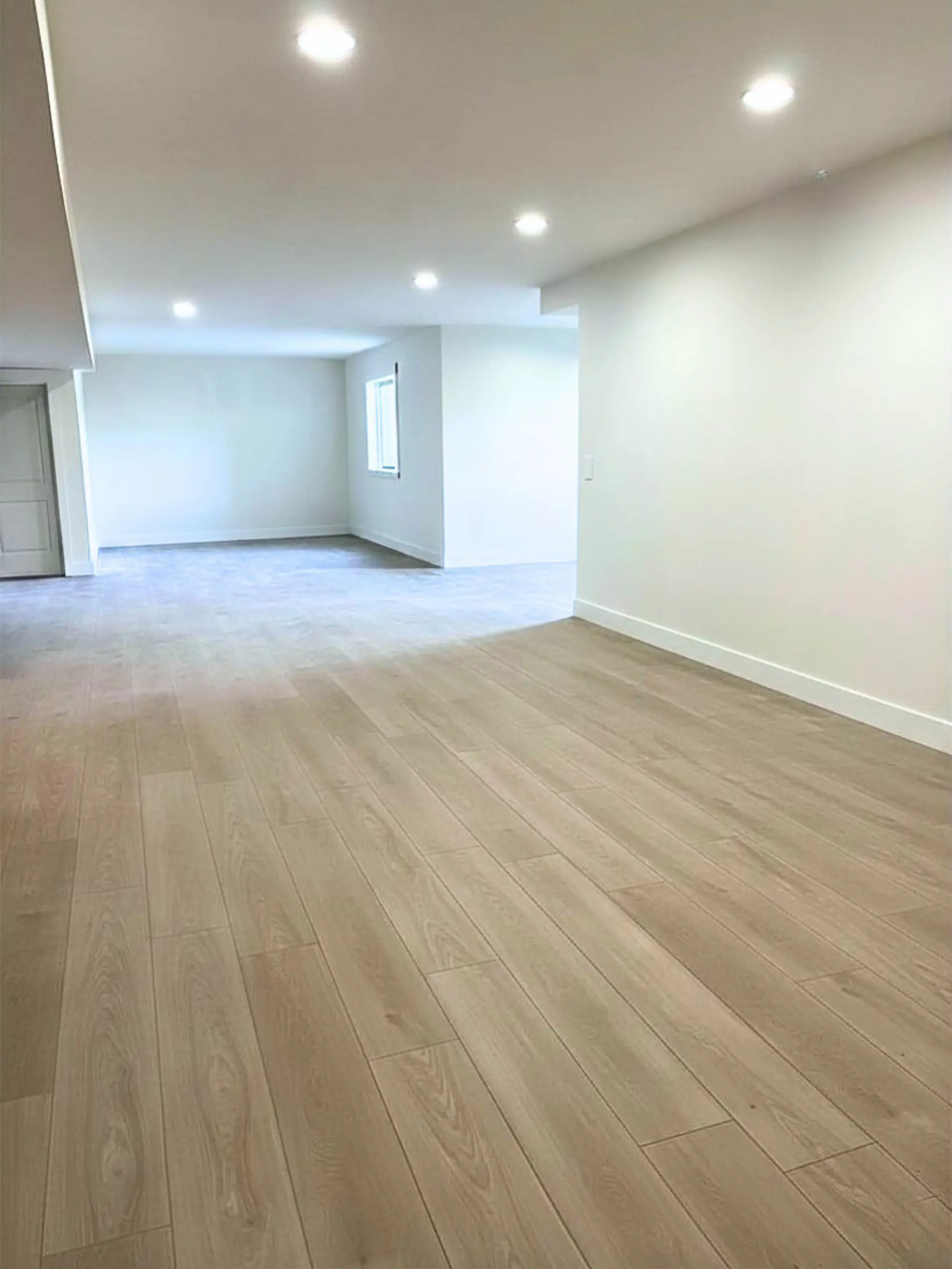 Fully finished basement with premium LVP flooring, recessed lighting, and clean drywall throughout